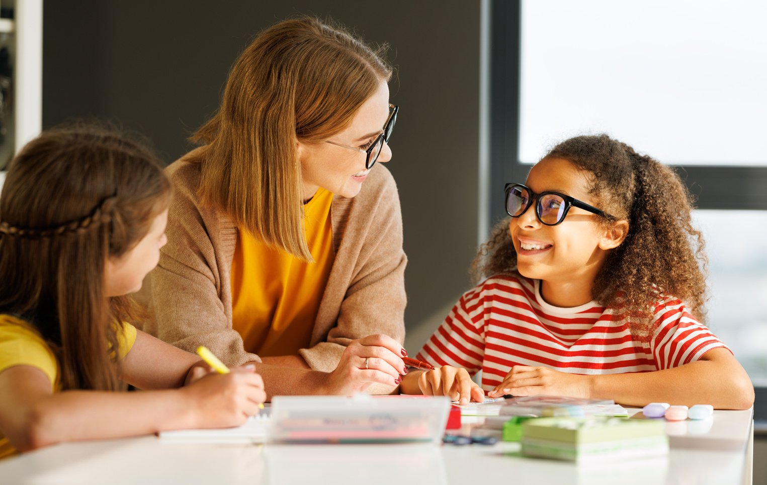 Teacher helping children with schoolwork